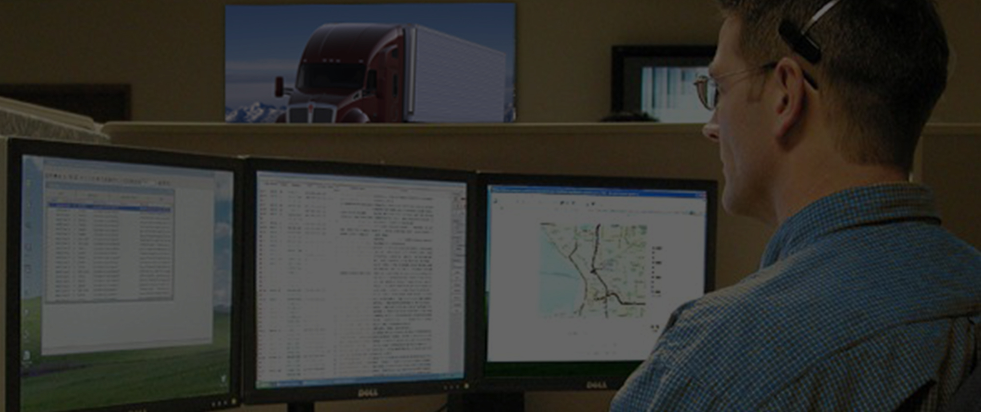 Fleet manager monitoring trucks on computer