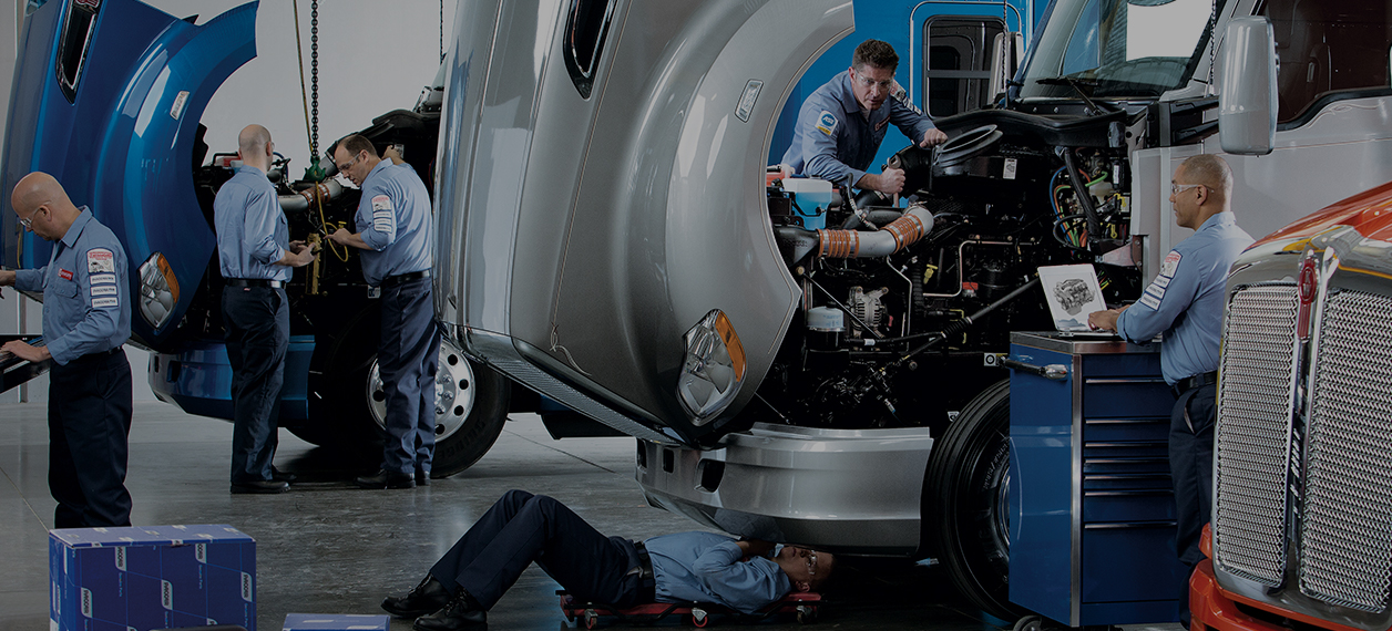 Kenworth mechanics working on trucks in garage