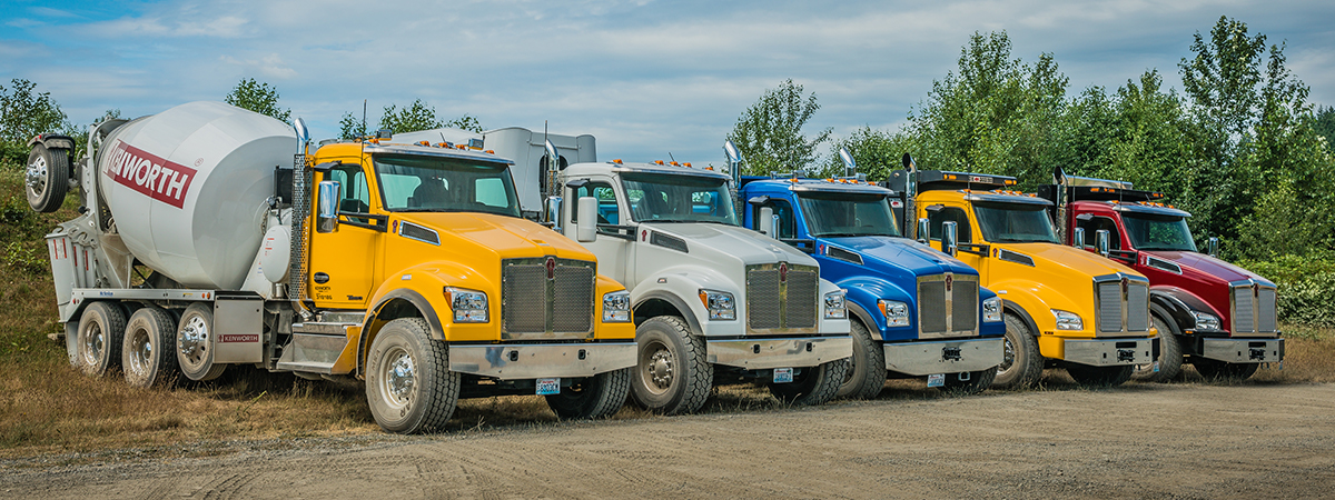 Row of Kenworth T880 trucks parked on dirt