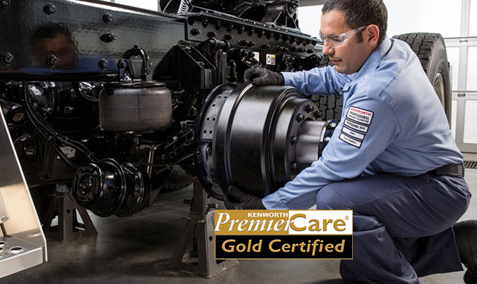 mechanic working on truck with Premier Care logo in the foreground