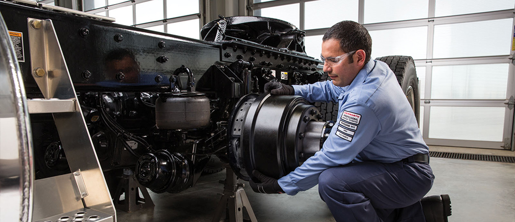 Kenworth technician adjusting wheel mount